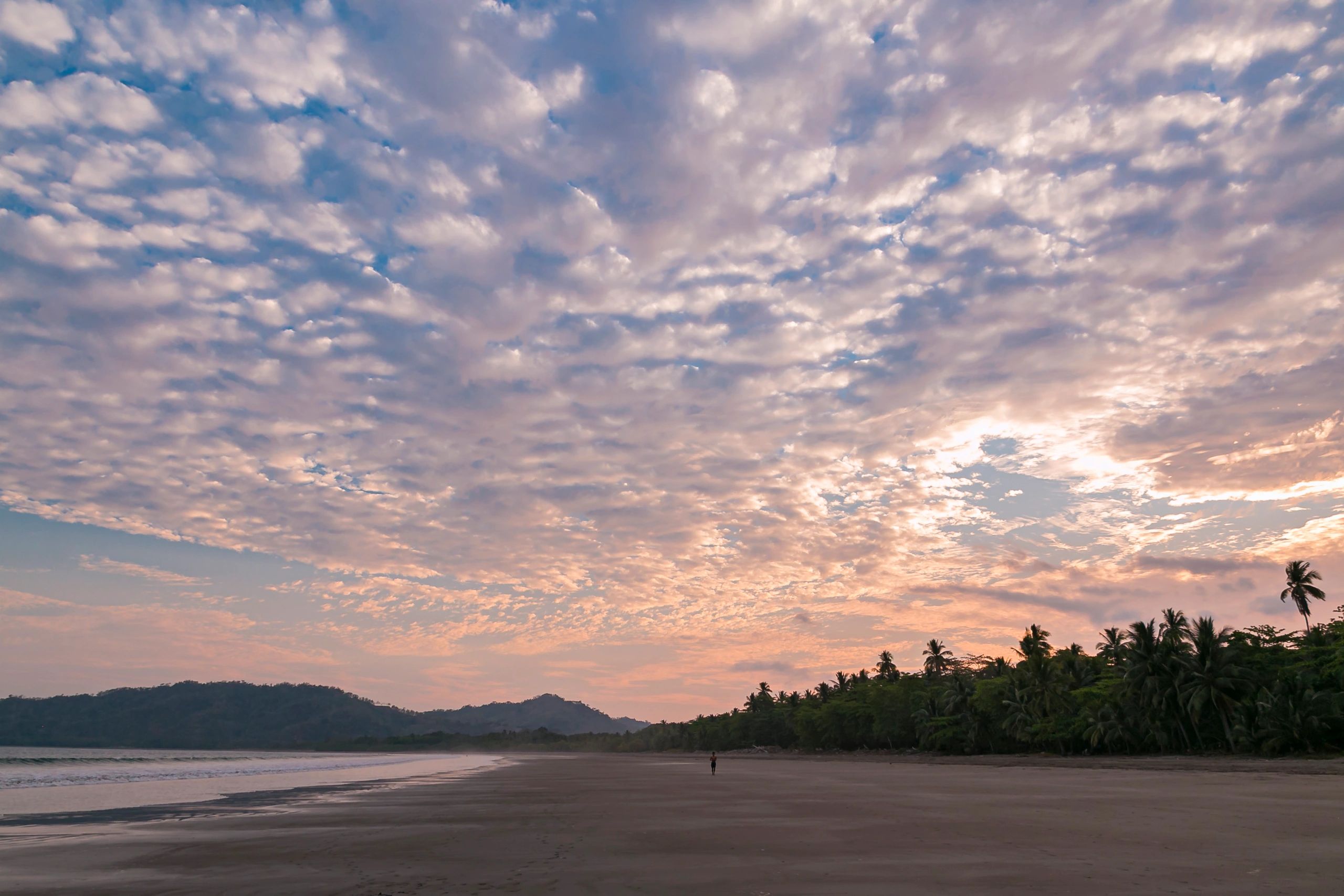 Person walking along a Costa Rican beach at sunset